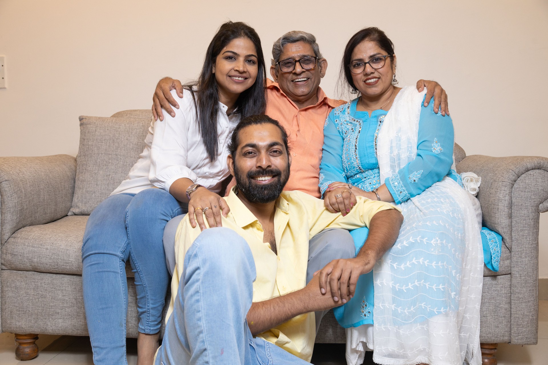 Happy Indian couple enjoying with senior father and mother while sitting in living room at home. relationship and bonding concept.